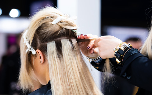 Applying hair extensions in salon